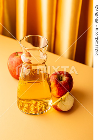 Glass decanter with apple juice and ripe apples Glass decanter with apple juice and ripe apples 99686928