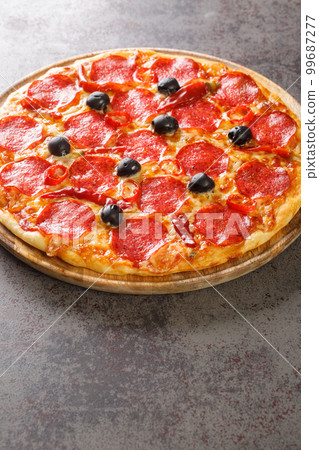 Spicy hot Diavola Pizza with sausage, mozzarella cheese, tomato sauce, chili peppers and black olives close-up on a wooden board. Vertical Spicy hot Diavola Pizza with sausage, mozzarella cheese, tomato sauce, chili peppers and black olives close-up on a wooden board. Vertical 99687277