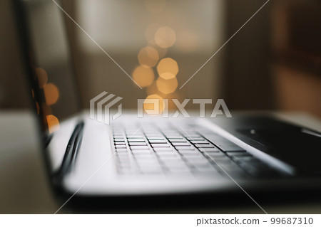 Close up of laptop keyboard with blank screen on a table by blurry bokeh lights background in the house or office modern, sunlight in morning Close up of laptop keyboard with blank screen on a table by blurry bokeh lights background in the house or office modern, sunlight in morning 99687310