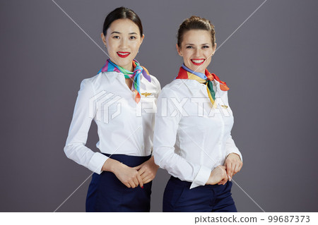 Portrait of happy stewardess women isolated on grey Portrait of happy stewardess women isolated on grey 99687373