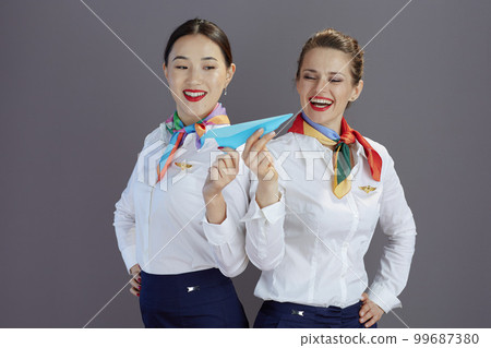 smiling elegant air hostess women isolated on grey 99687380