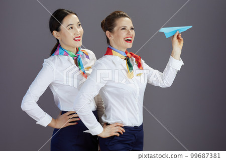 smiling elegant stewardess women against gray background smiling elegant stewardess women against gray background 99687381
