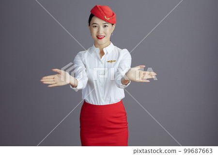 stewardess asian woman making hand gesture isolated on gray 99687663