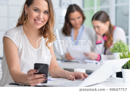 young women sit at the table and work in a modern office 99687757