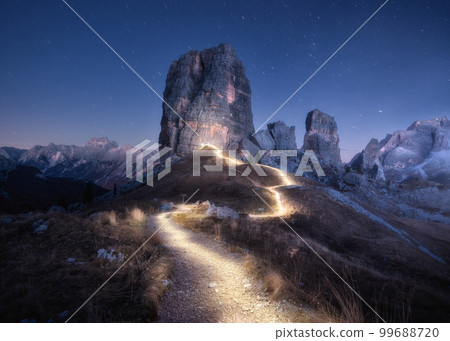Flashlight trails on mountain path against high rocks at night 99688720