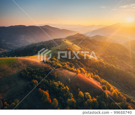 Aerial view of hills and mountains in fog at sunset in autumn Aerial view of hills and mountains in fog at sunset in autumn 99688740