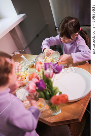 Daughters helping cooking apple pie in the kitchen. Daughters helping cooking apple pie in the kitchen. 99689635