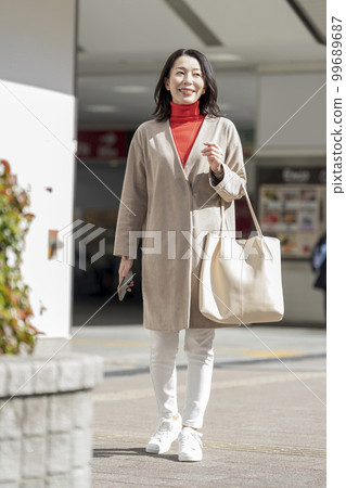A middle-aged woman walking down the street 99689687