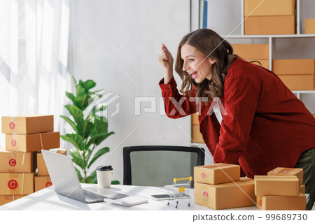 Concept of parcel delivery and selling online,Female seller or retailer happy while Using laptop check sales of day on online store to be packed into the parcel and ready to deliver to the customer Concept of parcel delivery and selling online,Female seller or retailer happy while Using laptop check sales of day on online store to be packed into the parcel and ready to deliver to the customer 99689730
