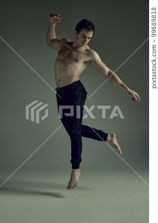 Full-length image of handsome young man with muscular athletic body posing shirtless in black pants over green studio background. Concept of men's health, beauty, sport Full-length image of handsome young man with muscular athletic body posing shirtless in black pants over green studio background. Concept of men's health, beauty, sport 99689818
