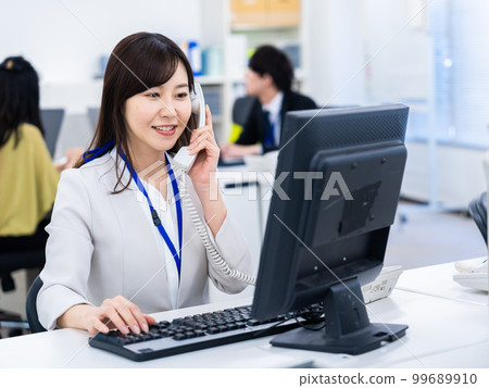 在辦公室使用固定電話的女性 在辦公室使用固定電話的女性 99689910