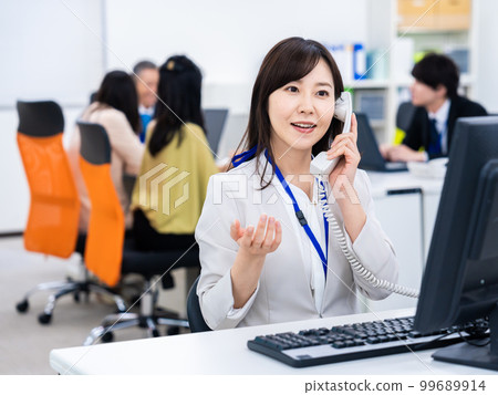 在辦公室使用固定電話的女性 在辦公室使用固定電話的女性 99689914