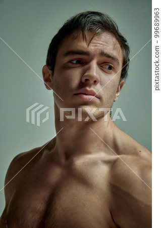 Relief body. Portrait of handsome young man with muscular body posing shirtless over pale green over studio background. Concept of men's health, beauty, sport Relief body. Portrait of handsome young man with muscular body posing shirtless over pale green over studio background. Concept of men's health, beauty, sport 99689963