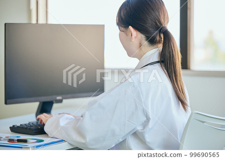 Young female doctor operating a personal computer Young female doctor operating a personal computer 99690565