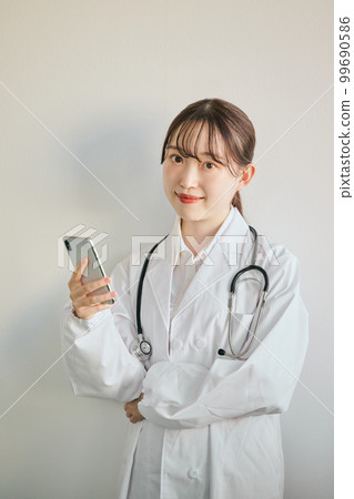Female doctor operating a smartphone Female doctor operating a smartphone 99690586