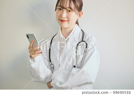 Female doctor operating a smartphone Female doctor operating a smartphone 99690588