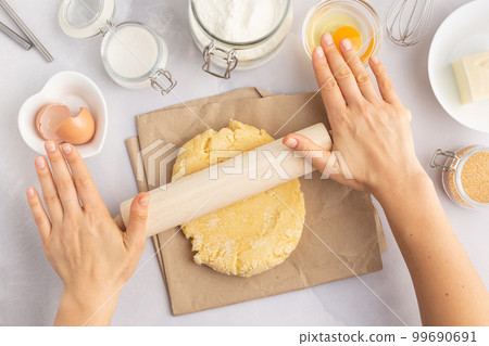 Various baking ingredients - flour, eggs, sugar, butter and kitchen utensils on grey background Various baking ingredients - flour, eggs, sugar, butter and kitchen utensils on grey background 99690691