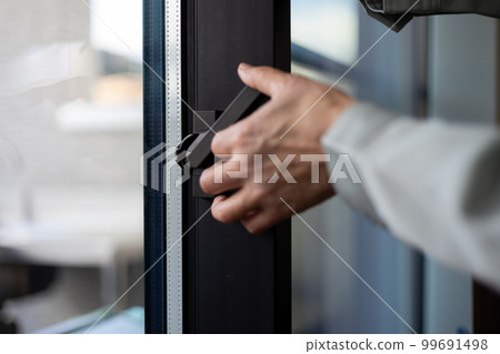 Male hand touching the crescent part of the sash window Male hand touching the crescent part of the sash window 99691498
