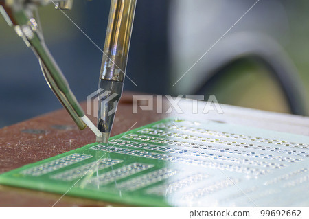 The automatic soldering machine operation with PCB board. The automatic soldering machine operation with PCB board. 99692662
