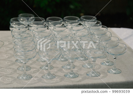 Empty cocktail glasses on a table with a white 99693039