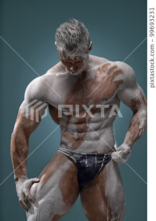 Muscular man touching himself, male posing in studio Muscular man touching himself, male posing in studio 99693231