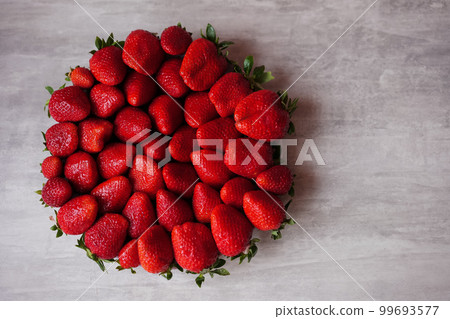 Delicious big ripe red strawberries on round plate.  99693577
