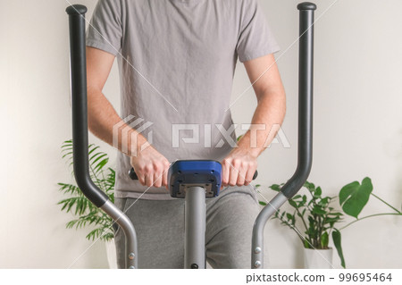 A man trains on an Elliptical Machine. Sports A man trains on an Elliptical Machine. Sports 99695464
