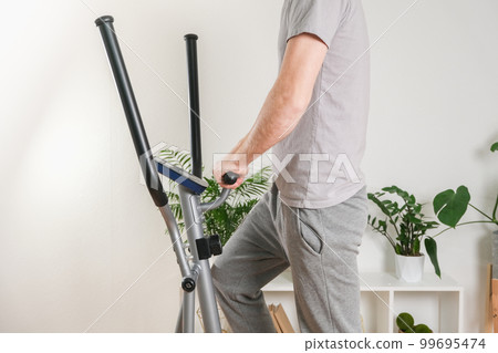A man trains on an Elliptical Machine. Sports A man trains on an Elliptical Machine. Sports 99695474