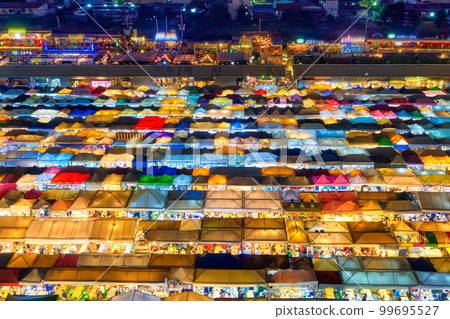 Colorful rows of outdoor market tents and food stalls at night, Asia.  99695527