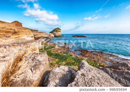Picturesque seascape with white rocky cliffs, sea bay, islets and faraglioni near by beach Spiaggia della Punticeddha Picturesque seascape with white rocky cliffs, sea bay, islets and faraglioni near by beach Spiaggia della Punticeddha 99695694