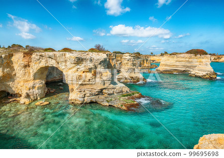 Stunning seascape with cliffs rocky arch and stacks (faraglioni) at Torre Sant Andrea Stunning seascape with cliffs rocky arch and stacks (faraglioni) at Torre Sant Andrea 99695698
