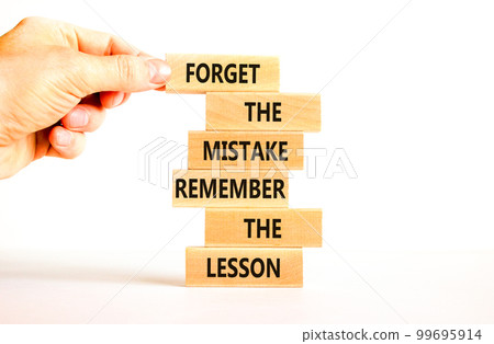 Lesson from mistake symbol. Concept words Forget the mistake remember the lesson on wooden blocks on a beautiful white table white background. Businessman hand. Business lesson from mistake concept. Lesson from mistake symbol. Concept words Forget the mistake remember the lesson on wooden blocks on a beautiful white table white background. Businessman hand. Business lesson from mistake concept. 99695914