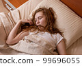 A girl very tired with her mouth open sleeps soundly on the bed 99696055