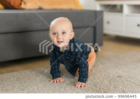Nursery baby boy crawling on floor indoors at home copy space and empty space for text - Baby curiosity and child development stages Nursery baby boy crawling on floor indoors at home copy space and empty space for text - Baby curiosity and child development stages 99696445