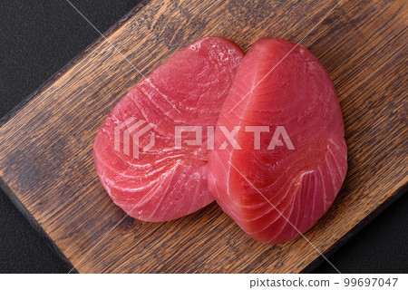 Two fresh slices of raw tuna fillet with spices and herbs Two fresh slices of raw tuna fillet with spices and herbs 99697047