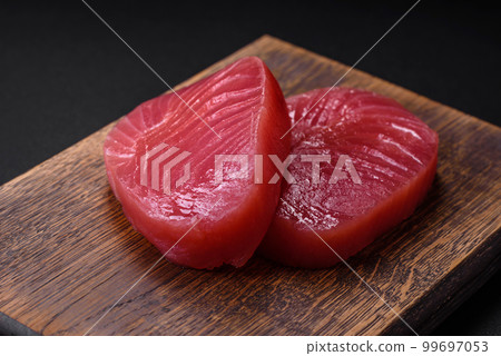Two fresh slices of raw tuna fillet with spices and herbs Two fresh slices of raw tuna fillet with spices and herbs 99697053