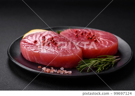 Two fresh slices of raw tuna fillet with spices and herbs 99697124