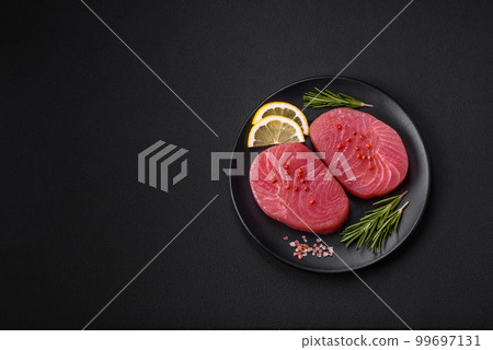 Two fresh slices of raw tuna fillet with spices and herbs 99697131