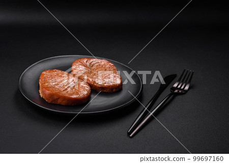 Two baked slices of tuna fillet with spices and herbs Two baked slices of tuna fillet with spices and herbs 99697160