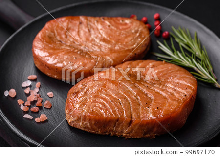 Two baked slices of tuna fillet with spices and herbs Two baked slices of tuna fillet with spices and herbs 99697170