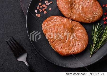 Two baked slices of tuna fillet with spices and herbs Two baked slices of tuna fillet with spices and herbs 99697171