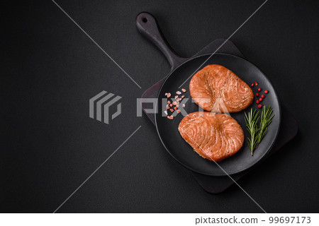 Two baked slices of tuna fillet with spices and herbs Two baked slices of tuna fillet with spices and herbs 99697173