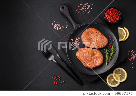 Two baked slices of tuna fillet with spices and herbs Two baked slices of tuna fillet with spices and herbs 99697175