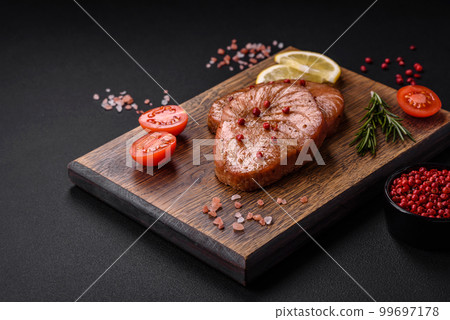 Two baked slices of tuna fillet with spices and herbs 99697178