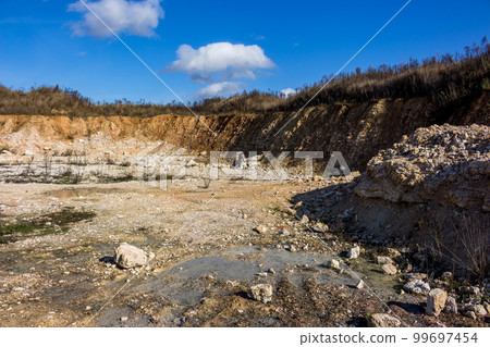Shallow abandoned limestone quarry, construction material extraction 99697454