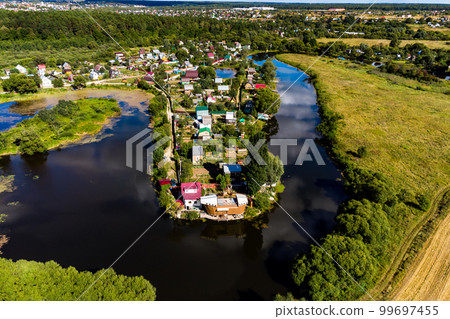 An aerial view of a dense suburban development on the shore of a winding reservoir An aerial view of a dense suburban development on the shore of a winding reservoir 99697455
