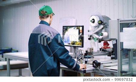 worker of printing equipment, adjusts, regulates the printing process. working process of printing packages for grain, agricultural products. 99697832