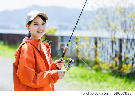 享受釣魚愛好的微笑的年輕女人 99697953