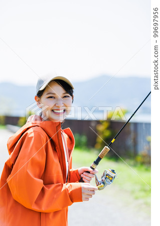 享受釣魚愛好的微笑的年輕女人 99697956
