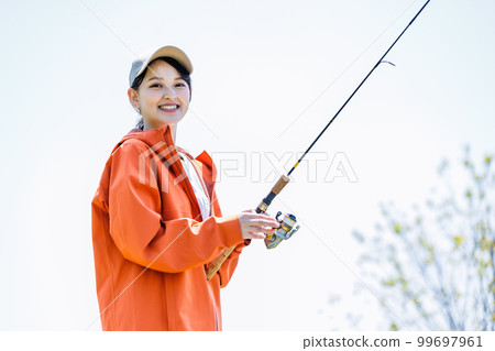 Smiling young woman enjoying hobby fishing Smiling young woman enjoying hobby fishing 99697961